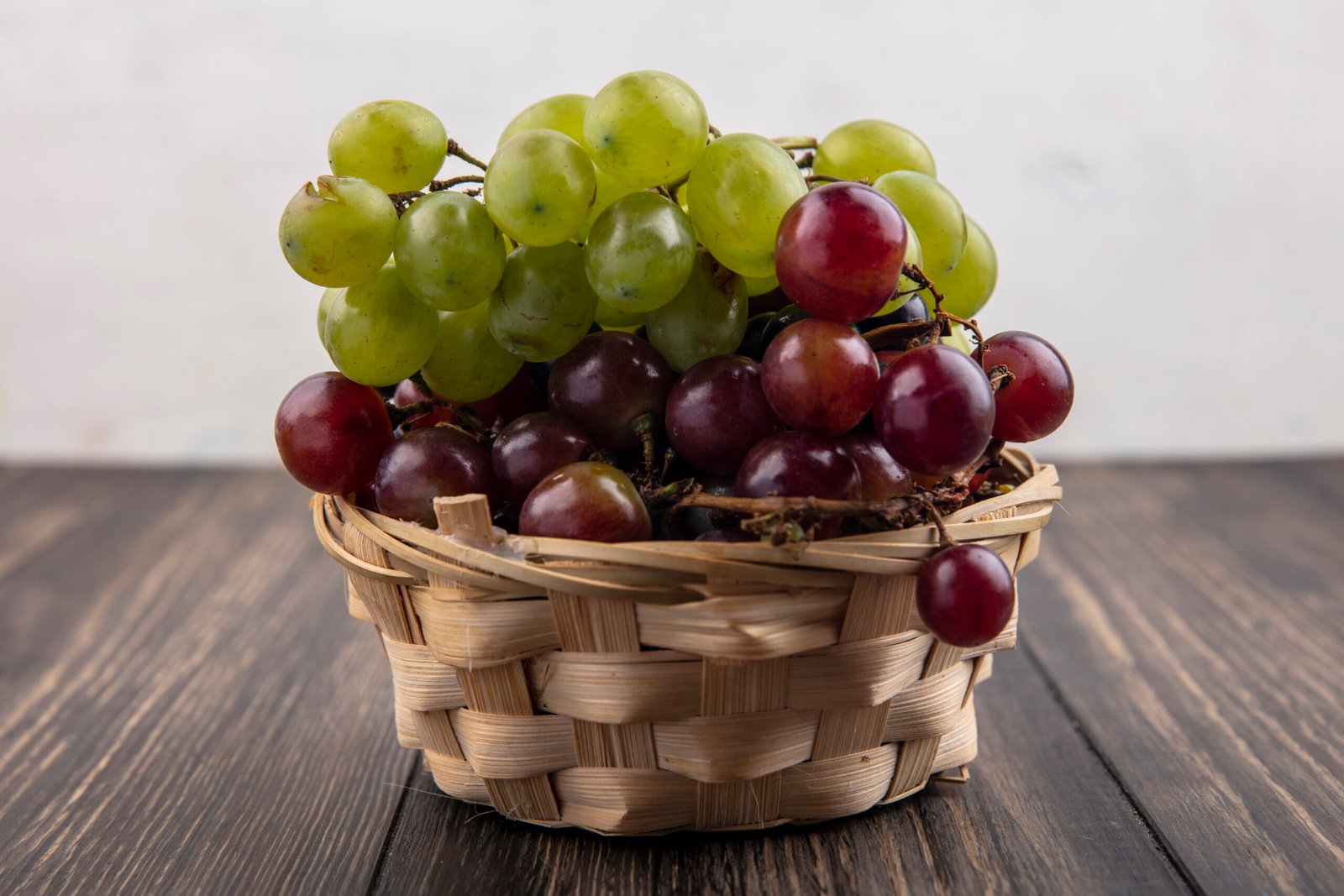 side view of white and red grapes in basket on wooden surface and white background SSUCv3H4sIAAAAAAAACpyRwW7DIAyG75P2DhHnRkpI0jZ9lWoHB0iCSqECsmmq+u4zECrOu0TxZ/u3f/P8/KgqMoGTjFyqZ4gwlkptzlvw0mjEzWHnVmgubEkEl95YCaqEE3i2argLhHpTKuBXTBLnwW9OuDBsRwy8WFAjwbdE2uia4ionYhI7MEXIoWBumyLLKIn/qzP9fGU3sAjNfuPChRErlIBk5JpKye3HC3svrcHGpSlcfRsGKhR0hdLDSib1UrQZv8Yr5zZmNu1tWOG9OVHGPGBS4cQzaorMV3AOy3nmxSCGb2ruxRxtfDSwqxKOLxHCtqM97Y8Nbeh5HMZmaPeC9HqrRJ24ThbCmN0kL63LsAE5diOMp3Gs5xk/PR36+tzSrhYtTJR3p2aYezz86w8AAP//AwCSr2sThwIAAA==
