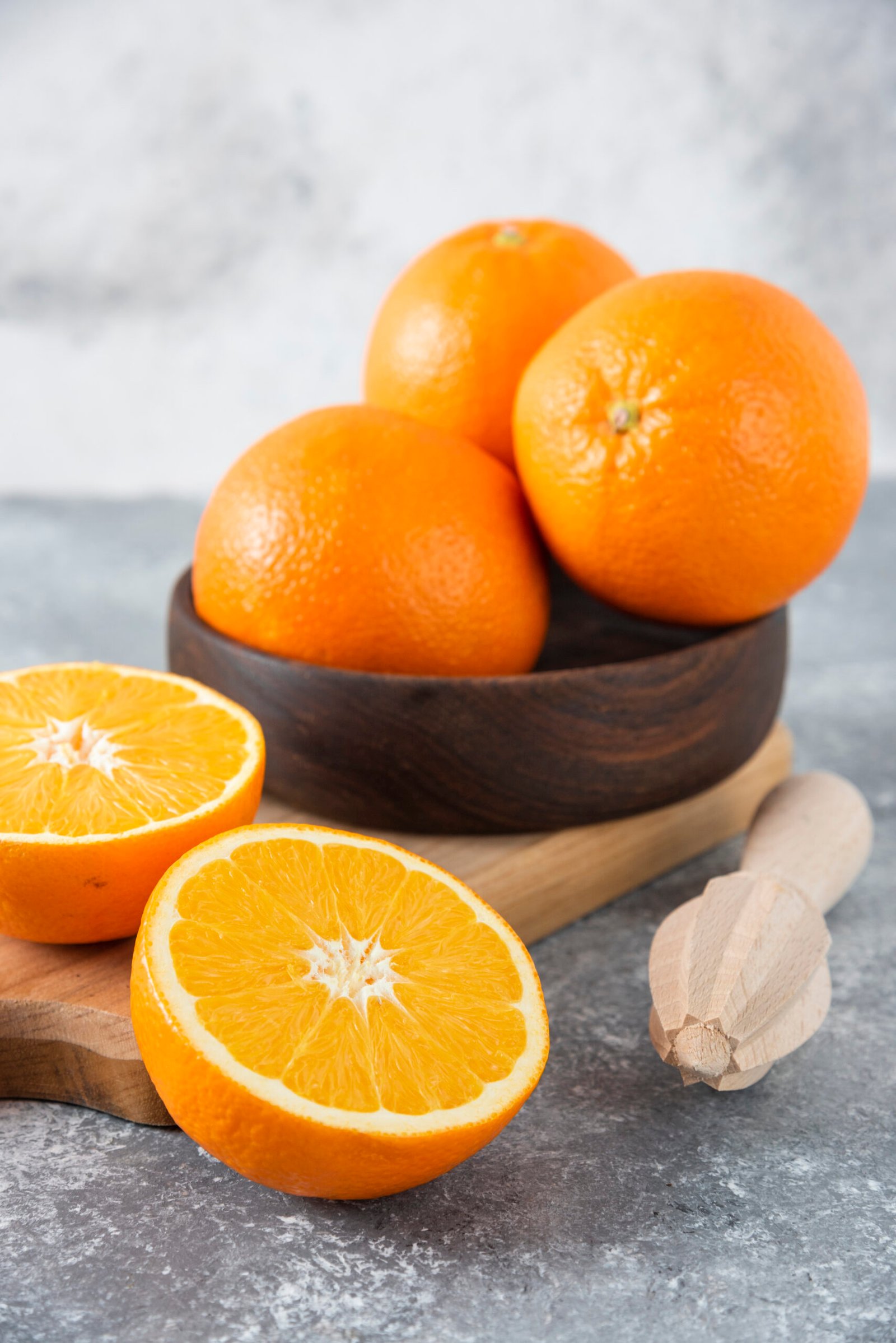 A wooden board full of juicy slices of orange fruit on stone background . High quality photo